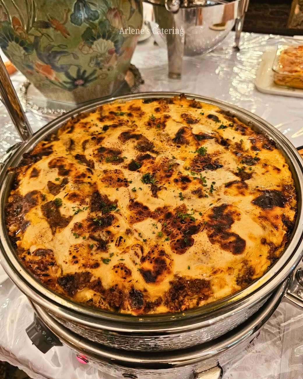 A baked casserole dish, browned top, in a catering tray