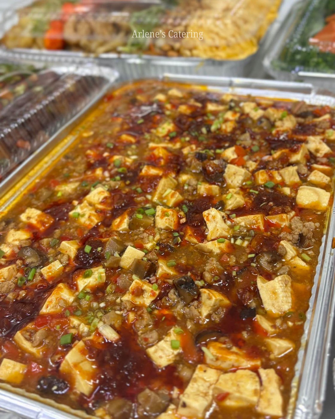 A tofu dish in savory sauce, catering tray